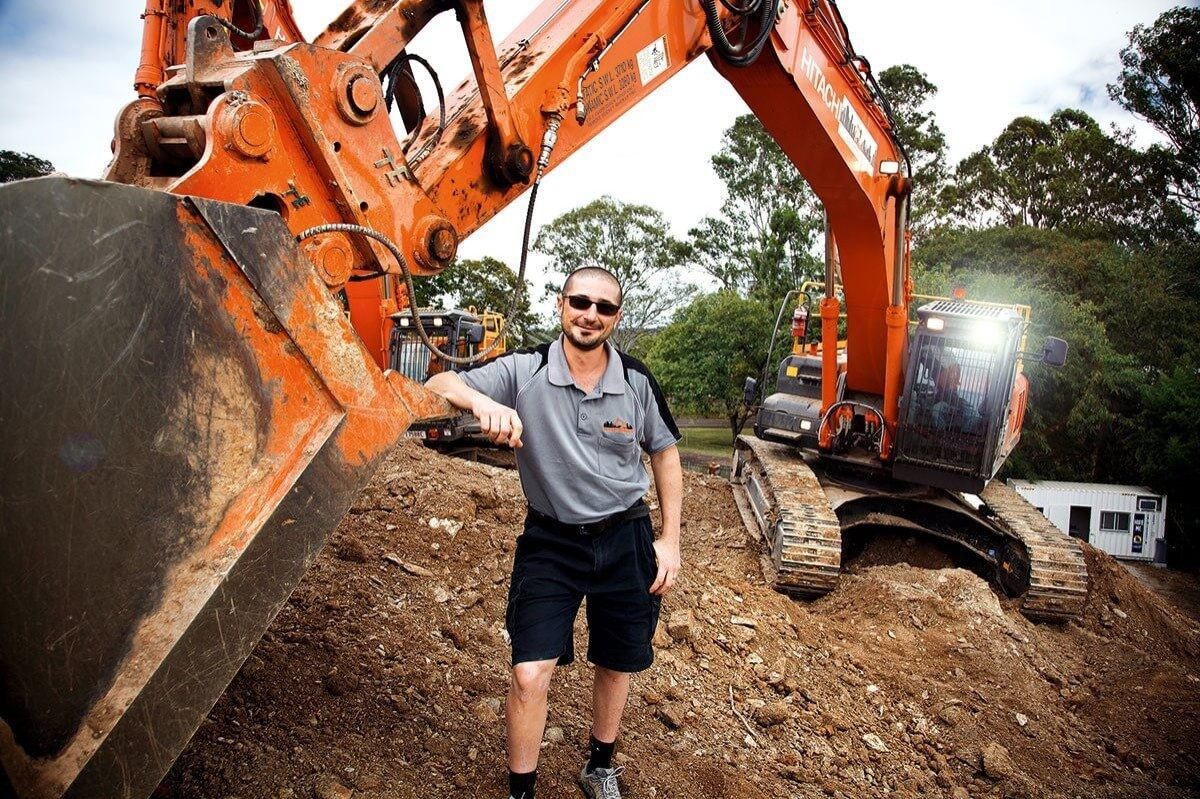The Owner of urban demolition leaning on an excavator 