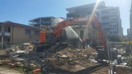 Large scale demolition of a property with construction equipment 