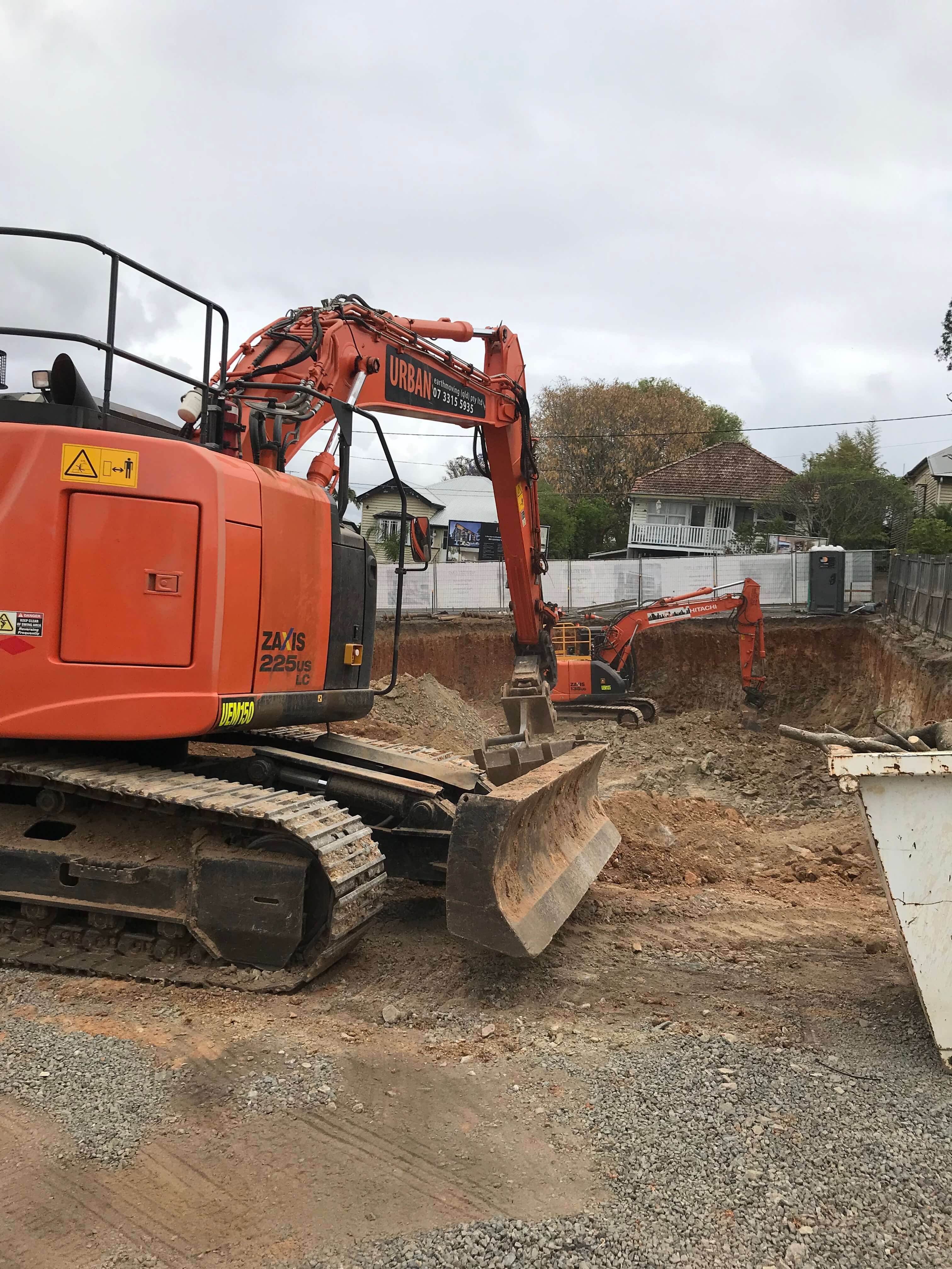 Lutwyche Basement Dig Two large orange excavators scooping dirt