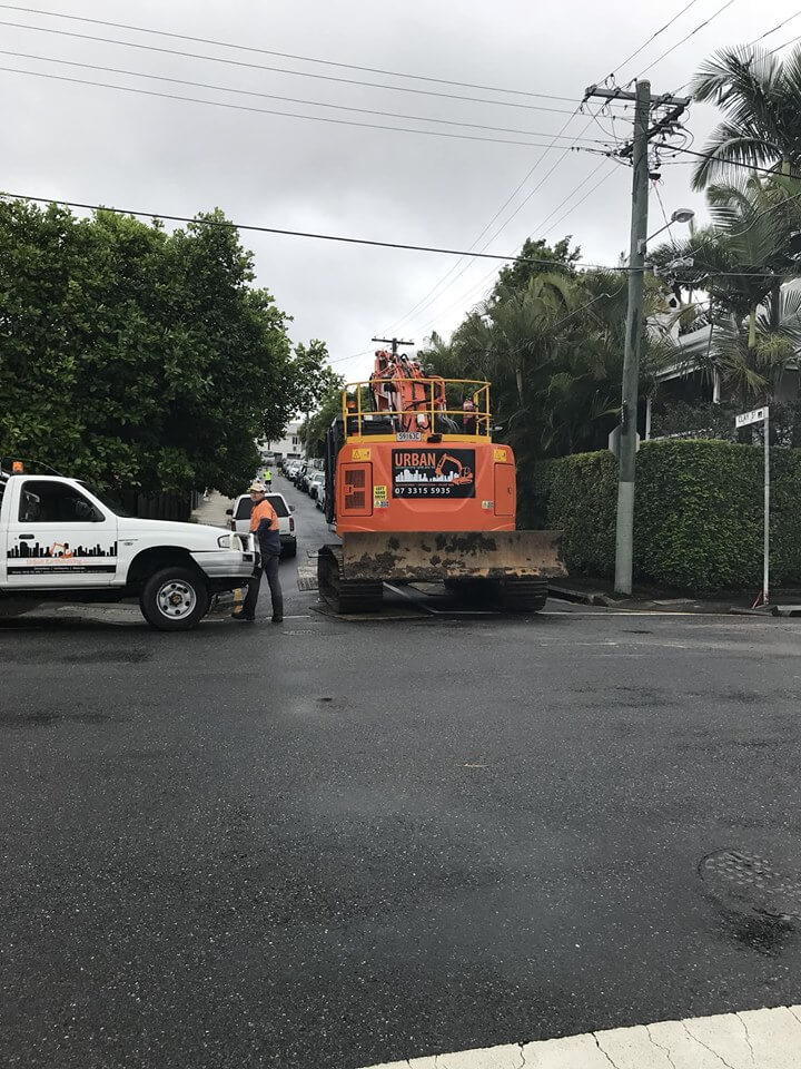 New Farm multi-residential A large orange excavator from Urban Demolition driving up a driveway