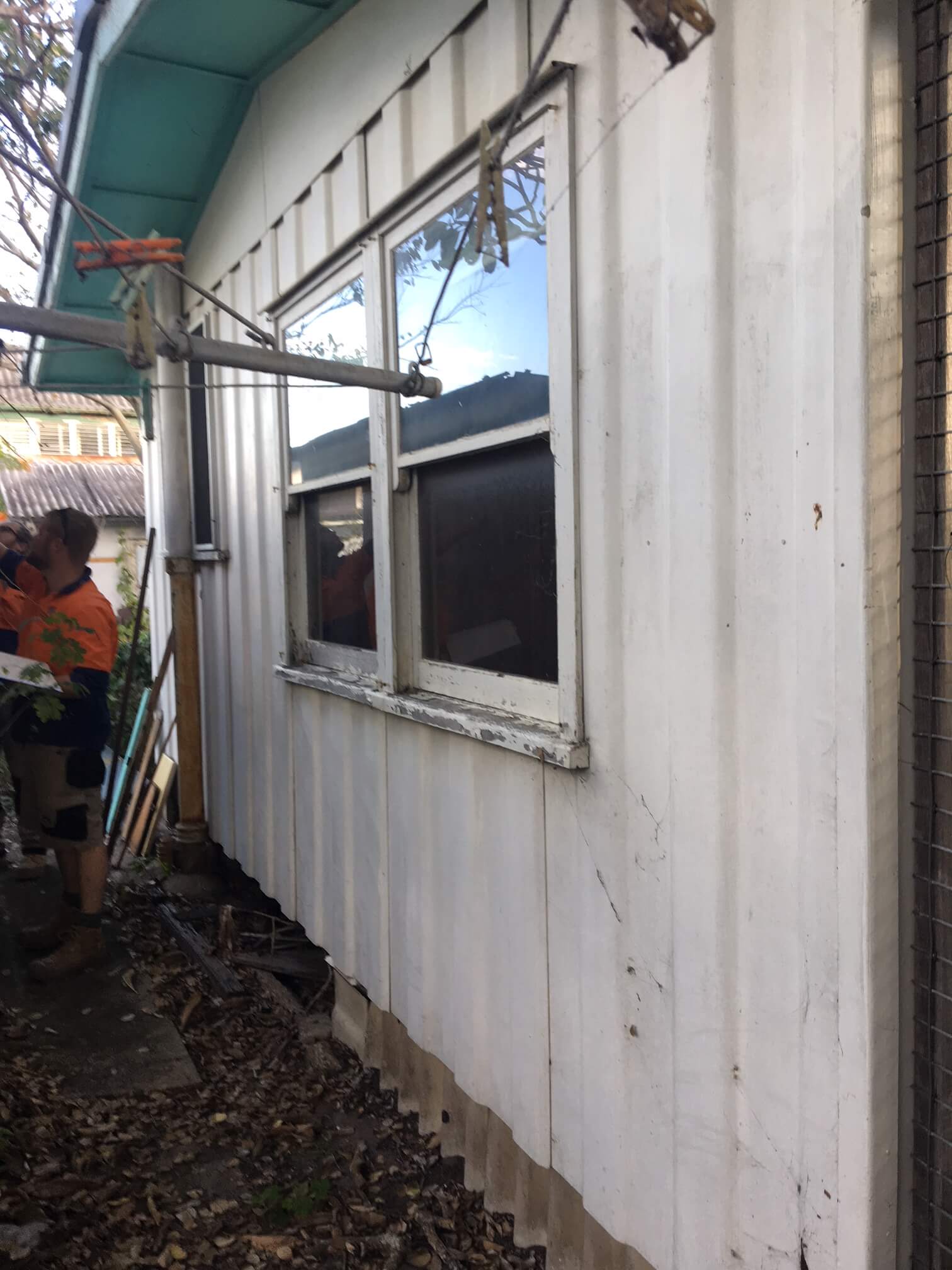 Asbestos Removal Services Brisbane White corrugated iron wall on the side of a house