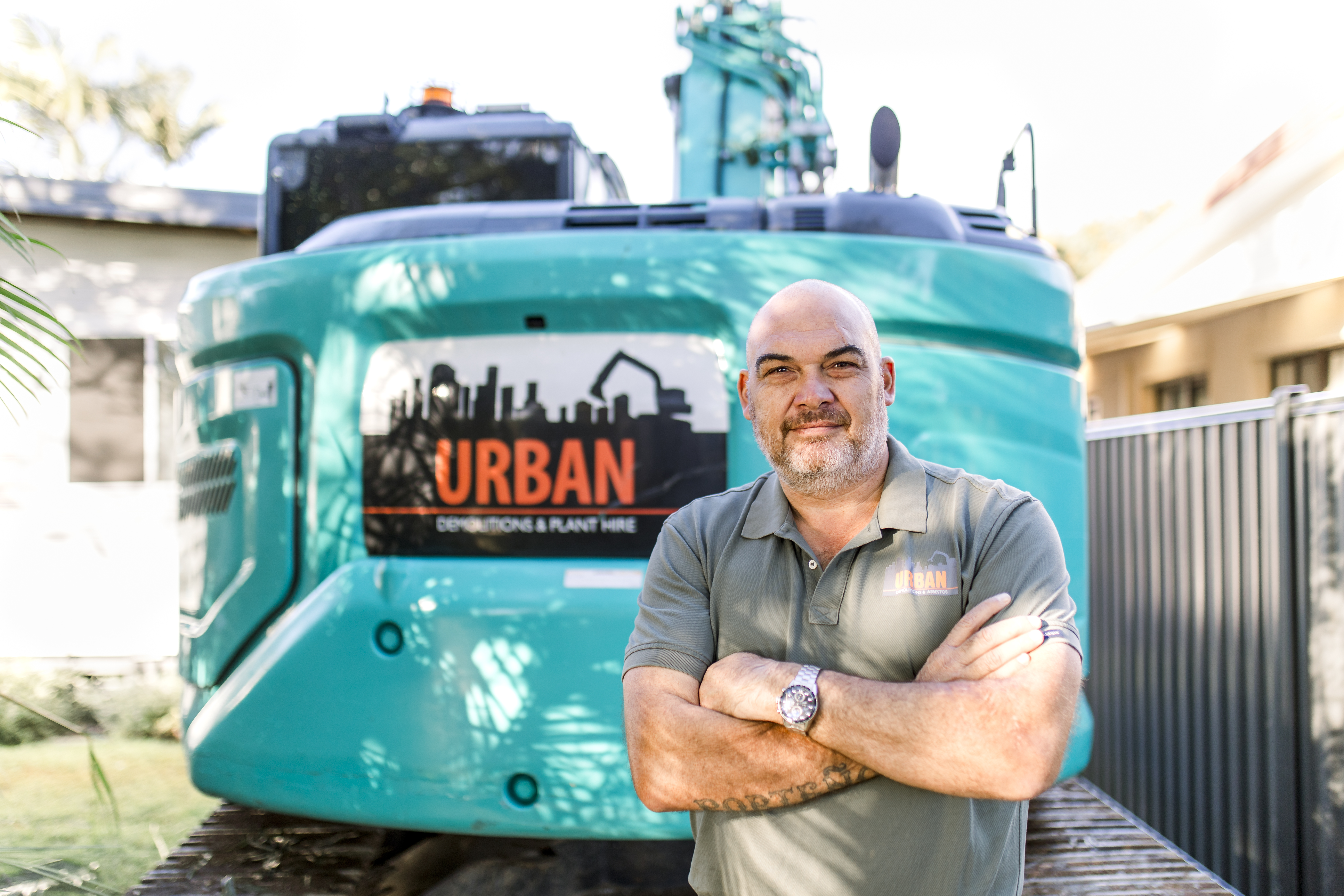 Demolition Services Brisbane Three workers wearing protective helmets evaluating a half-demolished site