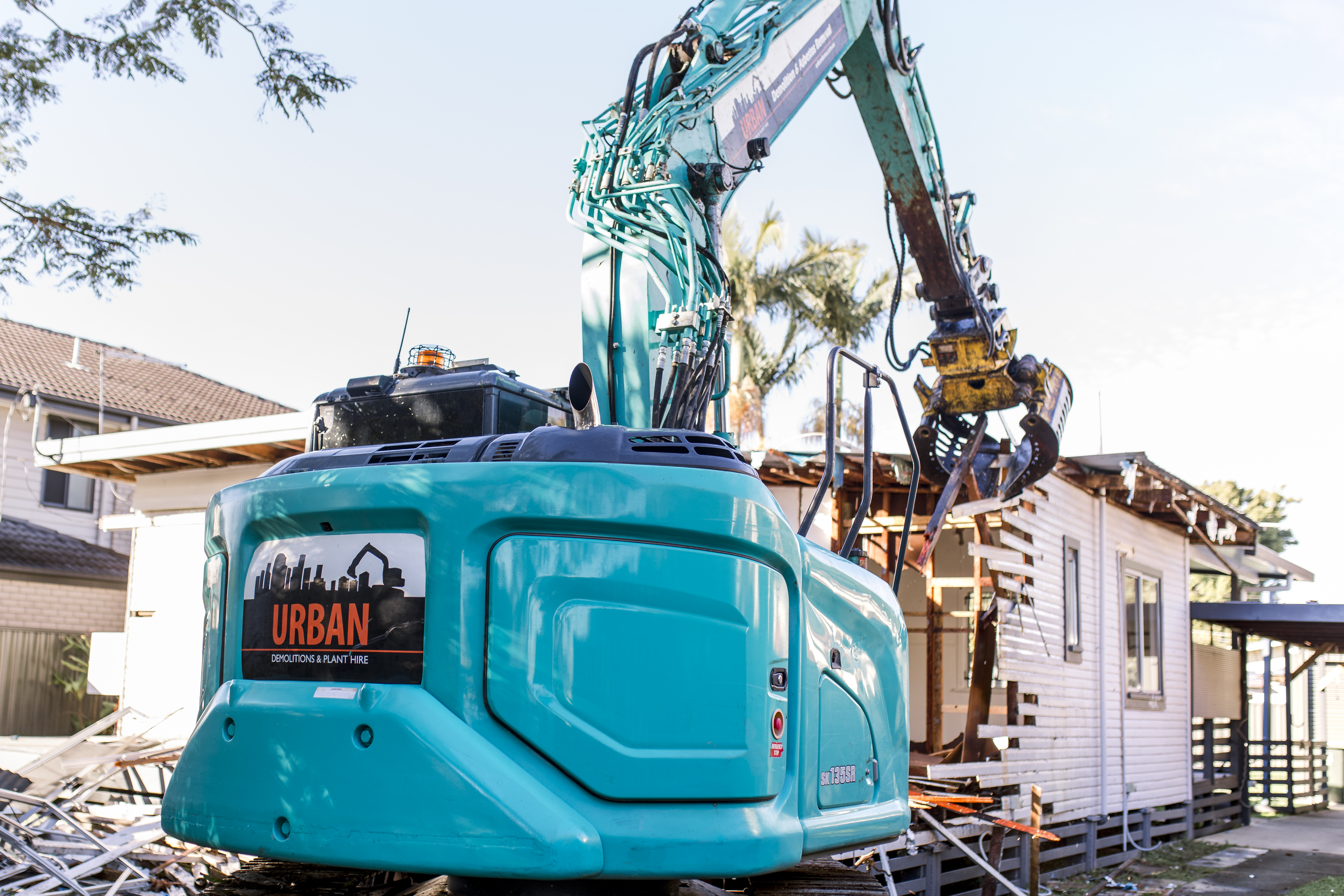 Demolition Services Brisbane Old residential house being demolished by an excavator
