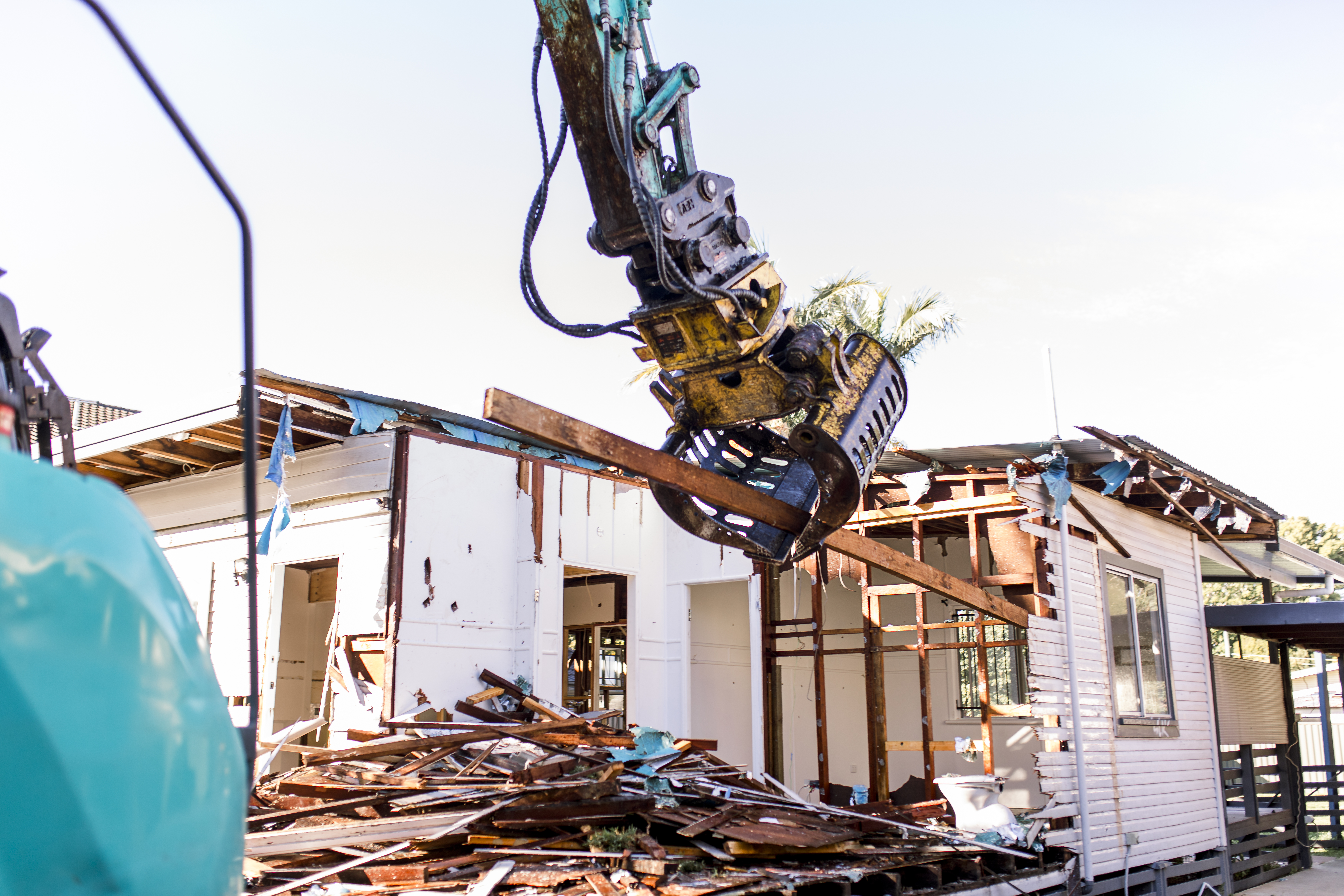 Demolition services brisbane Residential house being demolished by an excavator - Urban Demolitions