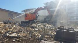 Large excavator demolishing a building